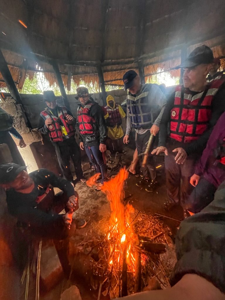 Účastníci expedice Zambezi 2022 schovaní v rozbořené chatrči před deštěm.